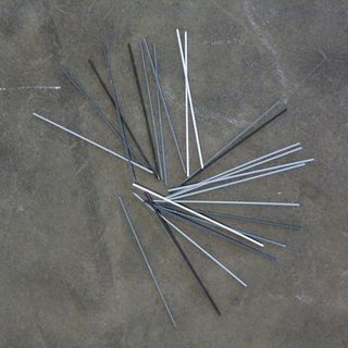 Des bâtonnets de mikado gris blancs et noirs sur un sol en béton